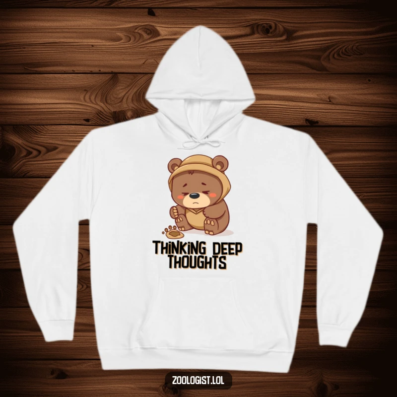 Funny hoodie showing a focused bear zoologist examining a detailed footprint, a humorous portrayal of wildlife research and intellectual pursuit.