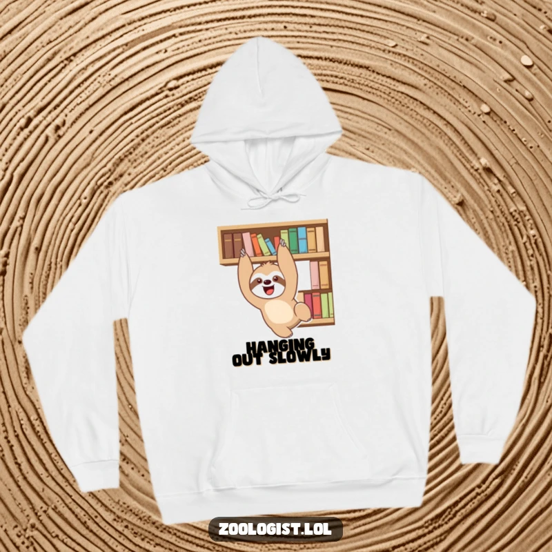 Funny delighted sloth character playfully dangling from a bookshelf, featured on a cozy hoodie, a humorous gift idea.