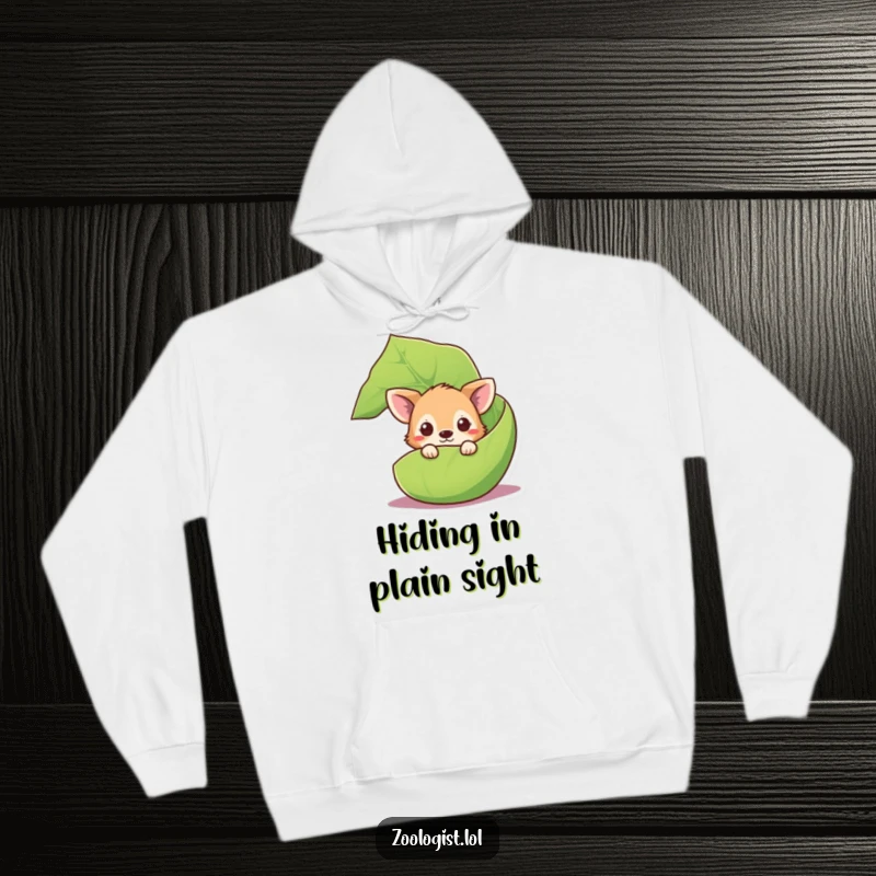 Funny curious animal hoodie with a cute creature peeking from behind a large leaf, offering cozy mystery.